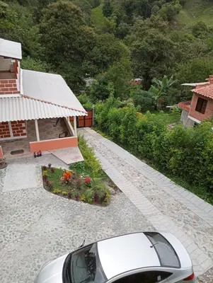 a car parked next to a house with a garden at Villa Paulina in Ebéjico