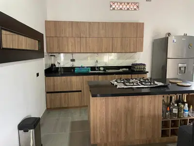 a kitchen with wooden cabinets and a counter top at Villa Paulina in Ebéjico