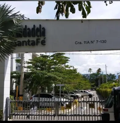 a sign for a car dealership with cars parked in a parking lot at Ciudadela Santafé De Antioquia in Santa Fe de Antioquia