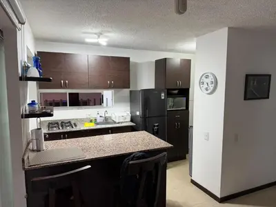 a kitchen with brown cabinets and a counter top at Ciudadela Santafé De Antioquia in Santa Fe de Antioquia