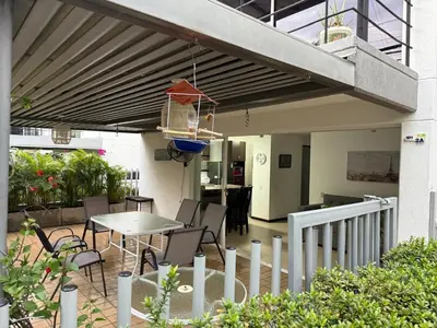 a patio with a table and chairs under a balcony at Ciudadela Santafé De Antioquia in Santa Fe de Antioquia