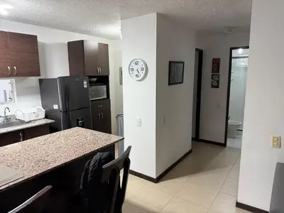 a kitchen with a counter and a sink and a refrigerator at Ciudadela Santafé De Antioquia in Santa Fe de Antioquia