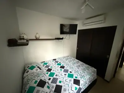 a bedroom with a bed with a quilt on it at Ciudadela Santafé De Antioquia in Santa Fe de Antioquia