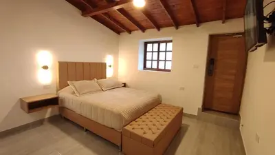 a bedroom with a bed with a bench and a window at Acogedor mini apartamento in Sonsón