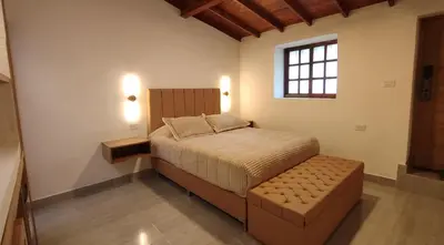 a bedroom with a bed with a ottoman and a window at Acogedor mini apartamento in Sonsón