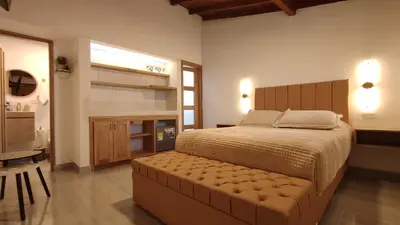 a bedroom with a large bed with a tufted foot board at Acogedor mini apartamento in Sonsón