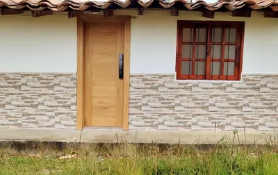 a house with a wooden door and a window at Acogedor mini apartamento in Sonsón