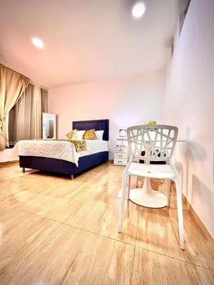 a bedroom with a bed and a white chair at AC Laureles Fast Internet for Nomads 5 Floor in Medellín