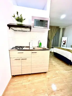 a kitchen with a sink and a bed in a room at AC Laureles Fast Internet for Nomads 5 Floor in Medellín