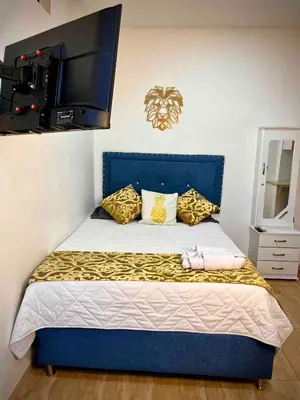 a bedroom with a blue bed with a tv on the wall at Ac Corner, at nice 5 floor fast wifi in Medellín