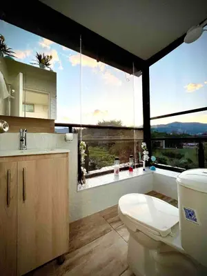 a bathroom with a toilet and a large window at Ac Corner, at nice 5 floor fast wifi in Medellín