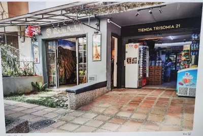 a store front with a bench in front of it at Hostal Machu Picchu Medellin in Estación El Salto