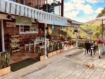 a restaurant with tables and chairs outside of it at SELENE Hostal Coworking Café in Medellín