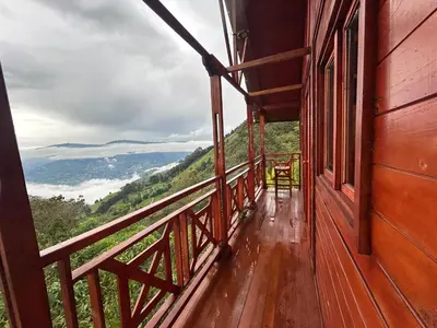 a balcony of a house with a view of the mountains at Cabaña Selvática y Manantiales, San Miguel Guarne in Guarne