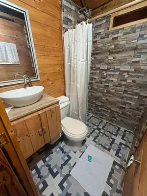a bathroom with a toilet and a sink at Cabaña Selvática y Manantiales, San Miguel Guarne in Guarne