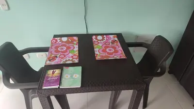 a black table with chairs and some books on it at Apartamento cómodo y silencioso in Santa Fe de Antioquia