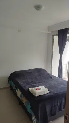 a room with a bed with a blue blanket and a window at Apartamento cómodo y silencioso in Santa Fe de Antioquia