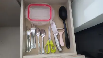 a drawer filled with silver utensils and a red box at Apartamento cómodo y silencioso in Santa Fe de Antioquia