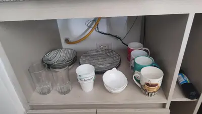 a shelf with cups and other items in a cabinet at Apartamento cómodo y silencioso in Santa Fe de Antioquia