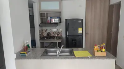 a kitchen counter with a sink and a refrigerator at Apartamento cómodo y silencioso in Santa Fe de Antioquia