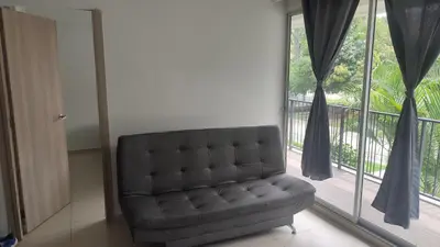 a couch in a living room with a large window at Apartamento cómodo y silencioso in Santa Fe de Antioquia