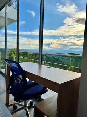 a desk with a blue chair in front of a window at Finca Doña Eva in Manizales