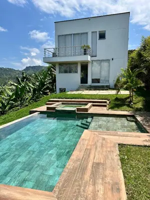 a house with a swimming pool in front of a house at Finca Doña Eva in Manizales