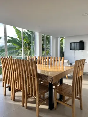 a wooden dining room table with chairs and a television at Finca Doña Eva in Manizales