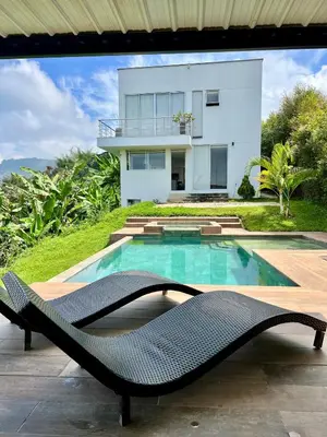 a villa with a swimming pool and a house at Finca Doña Eva in Manizales