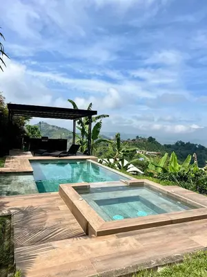 a swimming pool on a wooden deck with a view at Finca Doña Eva in Manizales
