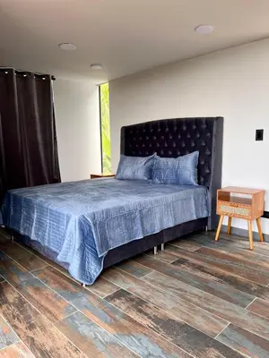 a bedroom with a bed with a blue comforter at Glamping La Nonita tipo cabaña Luxury in Manizales