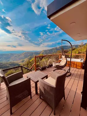 a patio with chairs and a hammock on a deck at Glamping La Nonita tipo cabaña Luxury in Manizales