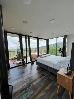 a bedroom with a bed and large windows at Glamping La Nonita tipo cabaña Luxury in Manizales