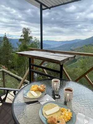 a glass table with two plates of food on it at Chalet Guadalupe - Girardota