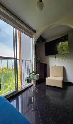 a living room with a couch and a large window at Medellin Las Palmas Beautiful View in Medellín