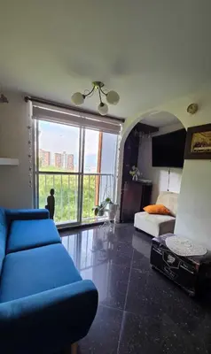 a living room with a blue couch and a large window at Medellin Las Palmas Beautiful View in Medellín