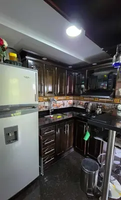 a kitchen with a white refrigerator and wooden cabinets at Medellin Las Palmas Beautiful View in Medellín
