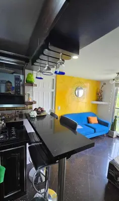a kitchen with a table and a blue couch at Medellin Las Palmas Beautiful View in Medellín