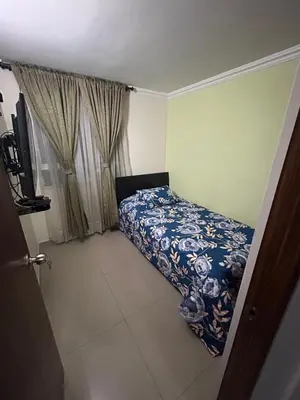 a small bedroom with a bed and a window at Apartment in Bello in Medellín
