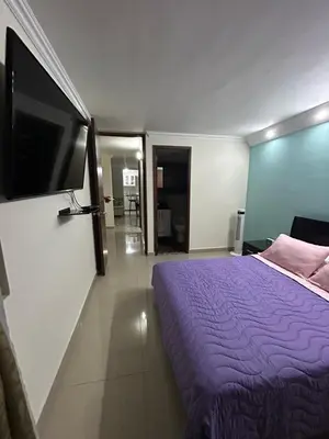 a bedroom with a purple bed and a flat screen tv at Apartment in Bello in Medellín
