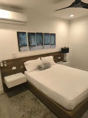 a bedroom with a large white bed with three windows at Poblado Luxury Suites in Medellín