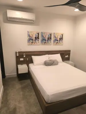 a bedroom with a large bed with white sheets at Poblado Luxury Suites in Medellín