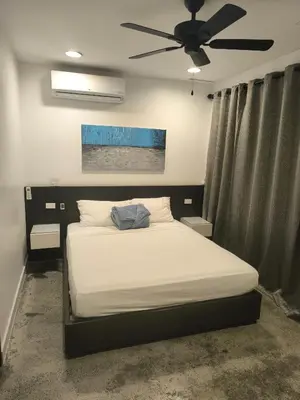a bedroom with a bed with a ceiling fan at Poblado Luxury Suites in Medellín