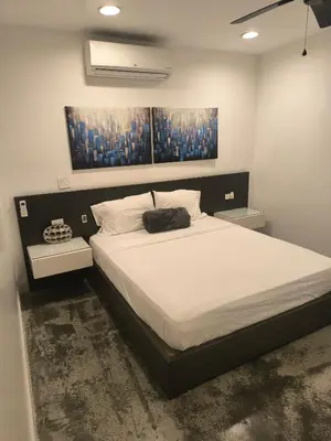 a bedroom with a large bed with white sheets at Poblado Luxury Suites in Medellín