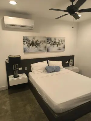 a bedroom with a bed with a ceiling fan at Poblado Luxury Suites in Medellín