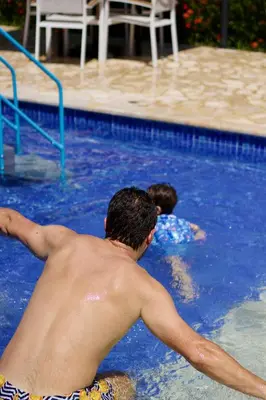 two boys are swimming in a swimming pool at Ivanna Hotel Campestre - Santa Fe de Antioquia in Santa Fe de Antioquia