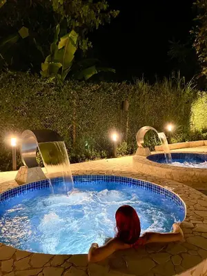 a woman laying in a hot tub with a fountain at Ivanna Hotel Campestre - Santa Fe de Antioquia in Santa Fe de Antioquia