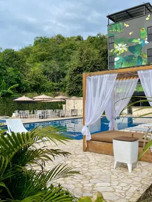 a bed and chairs next to a swimming pool at Ivanna Hotel Campestre - Santa Fe de Antioquia in Santa Fe de Antioquia