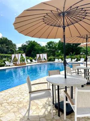 a table with an umbrella next to a swimming pool at Ivanna Hotel Campestre - Santa Fe de Antioquia in Santa Fe de Antioquia
