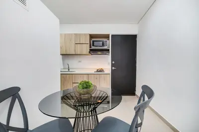 a dining room with a glass table and chairs at Apartamentos Oslo Tesoro by HOUSY in Medellín